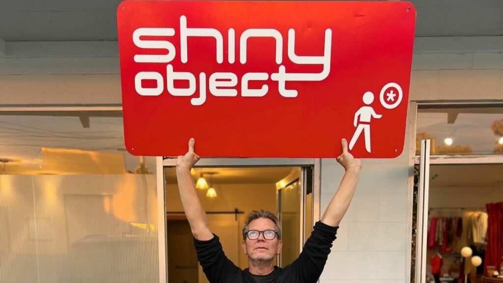 Ron lifting the Shiny Object sign overhead